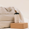 Mug isotherme Qwetch Allure Lin 350ml en inox beige rayé posé sur un bloc de liège chez Du Bruit dans la Cuisine